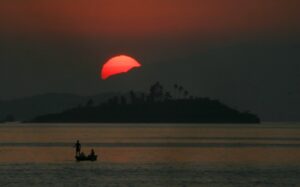 Paisagem. Ponto Turístico. Rio de Janeiro. São Gonçalo. Praia. Praia das Pedrinhas. Pescadores. Barco. Pôr do sol. Entardecer.